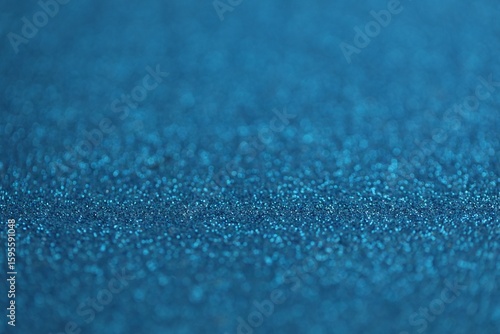 Beautiful blue glitter sparks texture as background with shallow depth of field