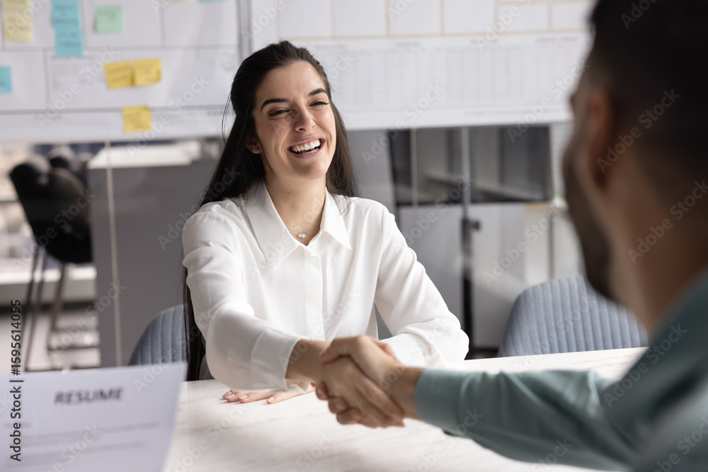 Fototapeta premium Smiling young Hispanic female vacancy applicant, seeker shaking hands with male hr manager, starting or finish interview or accepting job offer, making good first impression accomplish formal meeting