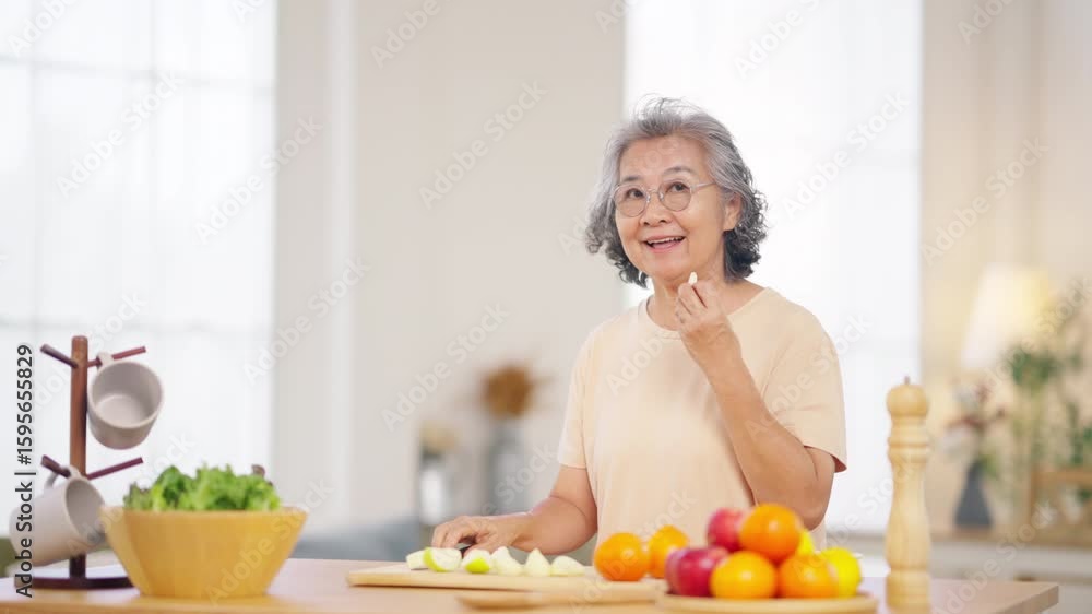 Portrait of Happy Asian senior woman having dinner at home. Elderly woman enjoy healthy lifestyle preparing organic clean food with vegetable and fruit. Retired people healthcare wellness self-care. Portrait of Happy Asian senior woman having dinner at home. Elderly woman enjoy healthy lifestyle preparing organic clean food with vegetable and fruit. Retired people healthcare wellness self-care.