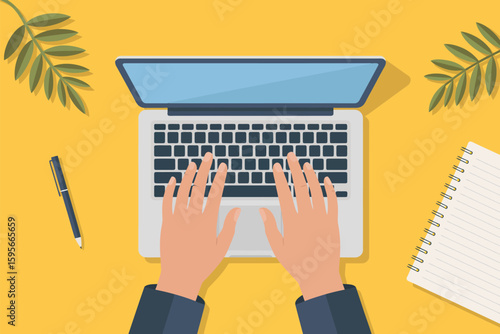 Top view of hands typing on a laptop with a pen, notebook, and leaves on a yellow background