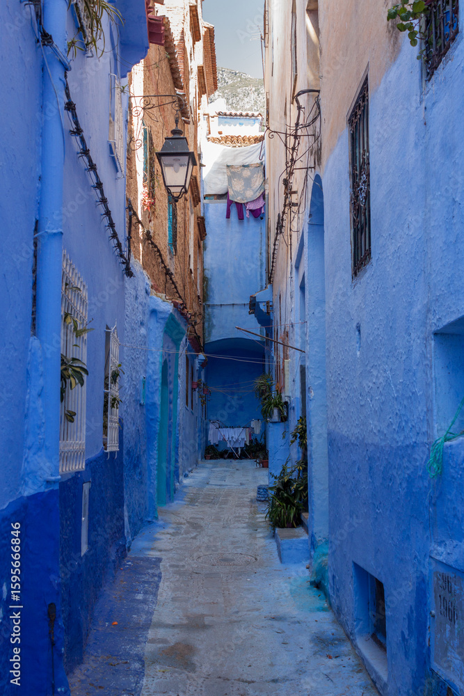 Fototapeta premium Blue Painted Alleyway with Mountain View in Chefchaouen Morocco