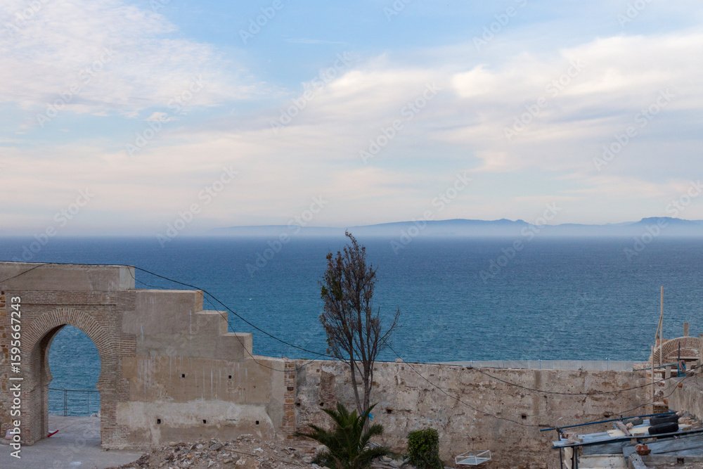 The Spanish Coast Peeks Through the Ocean Haze on the Horizon from Behind a Brick Wall Surrounding the Tangier Medina in Morocco The Spanish Coast Peeks Through the Ocean Haze on the Horizon from Behind a Brick Wall Surrounding the Tangier Medina in Morocco