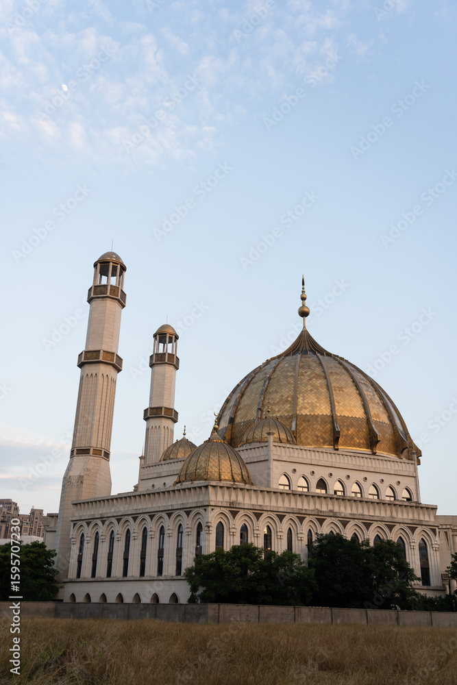 Obraz premium Grand mosque with golden domes and tall minarets.