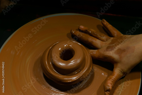 A picture of hands of a child and a teacher teaching pottery showing education, self development, creativity and growth. Children, eager, cute, curious, castle, stone, water, models, quick.