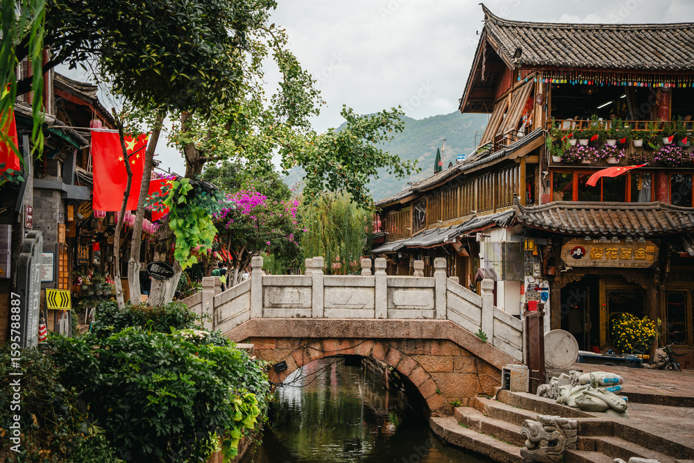Fototapeta premium Riverside pavilion with stone bridge in Lijiang Old Town, China