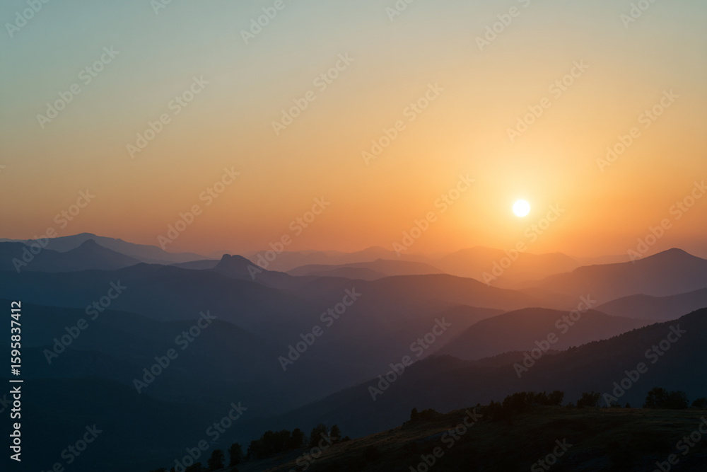 Fototapeta premium Layers of Mountains in a Colorful Sunrise Mist