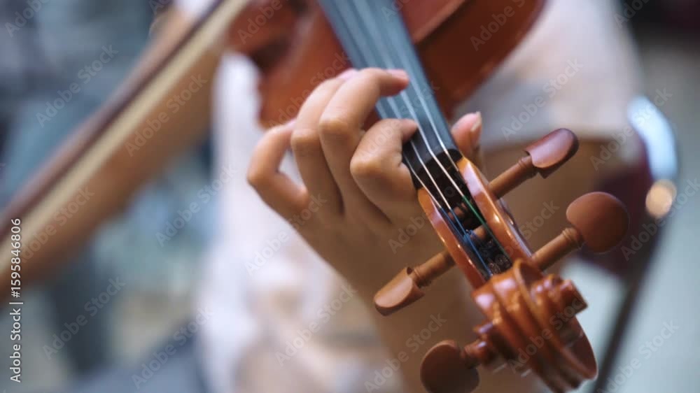 Close-Up of Violinist's Hands Playing the Violin in Orchestra Rehearsal Close-Up of Violinist's Hands Playing the Violin in Orchestra Rehearsal