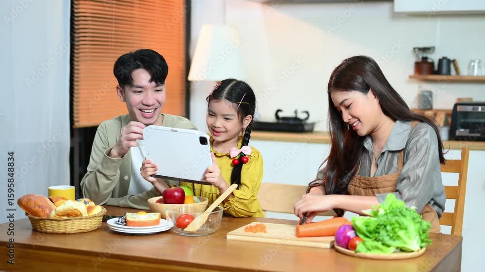 Happy Asian family enjoying breakfast, cooking, and bonding in a cozy kitchen. Parents and daughter share love, food Happy Asian family enjoying breakfast, cooking, and bonding in a cozy kitchen. Parents and daughter share love, food