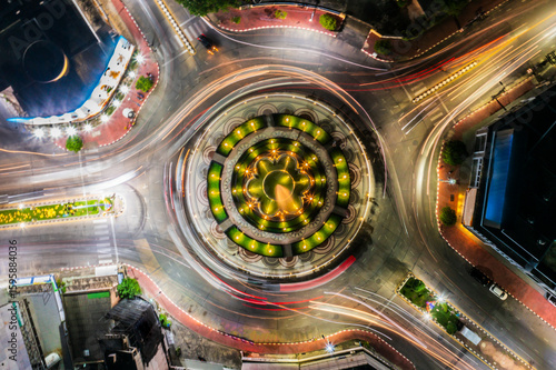 Vászonkép Hat Yai roundabout at night, Thailand, captured with long exposure showing light trails of cars circling the illuminated urban intersection