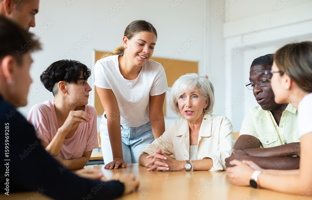 Adult students of different ages and teacher brainstorming round table in university classroom Adult students of different ages and teacher brainstorming round table in university classroom