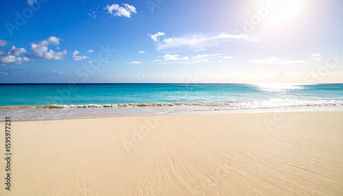 Tropical beach with white sand and blue sea under sunlight.