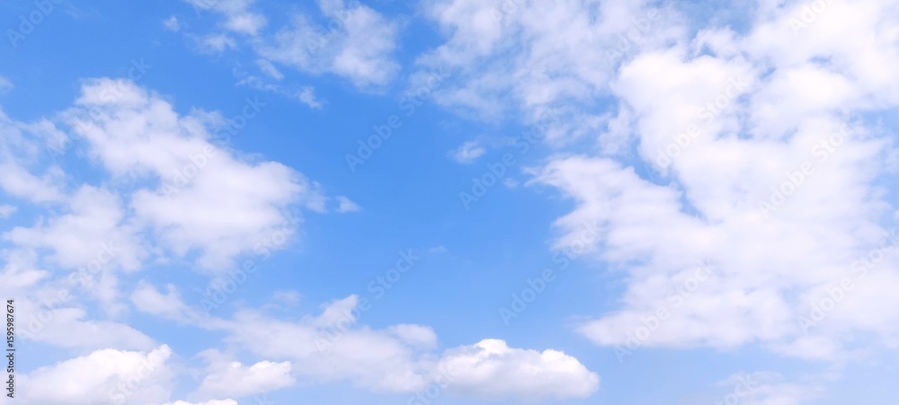 Fototapeta premium White cumulus clouds in blue sky with daylight natural background. Blue sky with clouds. Soft white clouds float in the clear blue sky. Clear blue sky, bright spring, wallpaper landscape.