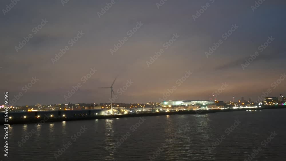 liverpool united kingome june 25 2024 Nighttime Waterfront View of Illuminated Cityscape With Wind Turbine Near Water liverpool united kingome june 25 2024 Nighttime Waterfront View of Illuminated Cityscape With Wind Turbine Near Water