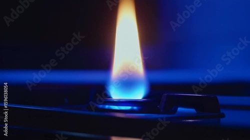 Glowing Flame Burning on Gas Hob in Dark Kitchen Close Up