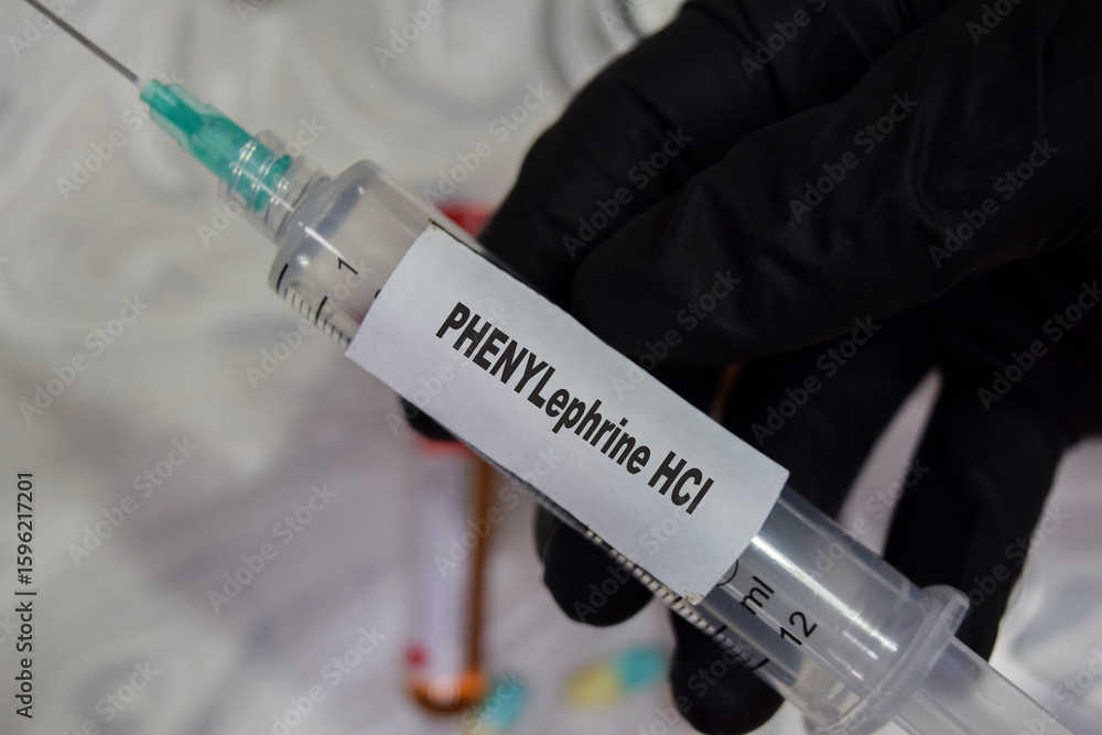 Naklejka premium Phenylephrine HCI vaccination drug syringe in black gloved hands. Medical concept
