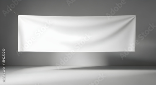Modern minimalistic blank white banner hanging on gray wall for advertising or display purposes in contemporary interior design setting with soft lighting and shadow effects