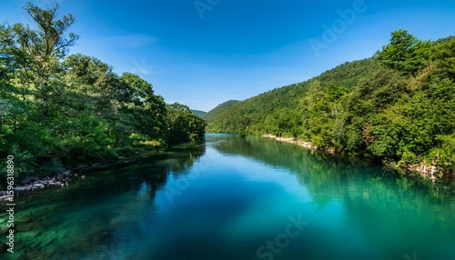 a river with a greenish blue color the water is calm and clear the trees surrounding the river are lush and green