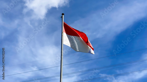 Indonesian Flag, The Red and white Flag, national symbol of Indonesia on the top. isolated blue sky background. Good structure for using background needed or independence day