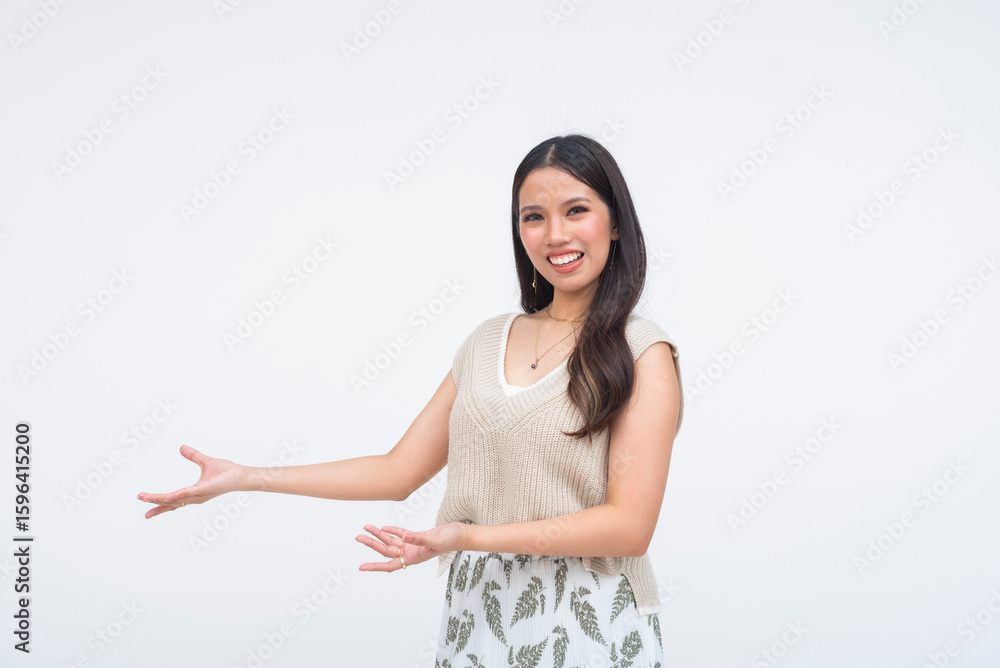 Young Asian woman smiling confidently while extending both arms to the right, proudly presenting something off-frame in a friendly and inviting pose with Gen Z charm and soft glam look. Young Asian woman smiling confidently while extending both arms to the right, proudly presenting something off-frame in a friendly and inviting pose with Gen Z charm and soft glam look.