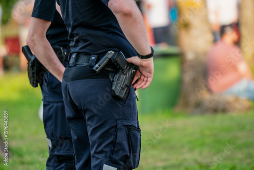 Fotografie Police officers on duty at public event, armed law enforcement in uniform standi