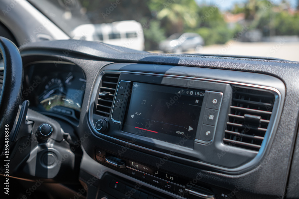 Obraz premium Modern Car Interior With Touchscreen Display Showcasing Audio Controls and Dashboard Features in a Sunny Outdoor Setting
