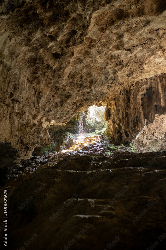 Obraz premium Exploring a Mysterious Cave With Natural Light Streaming Through During Daylight Hours