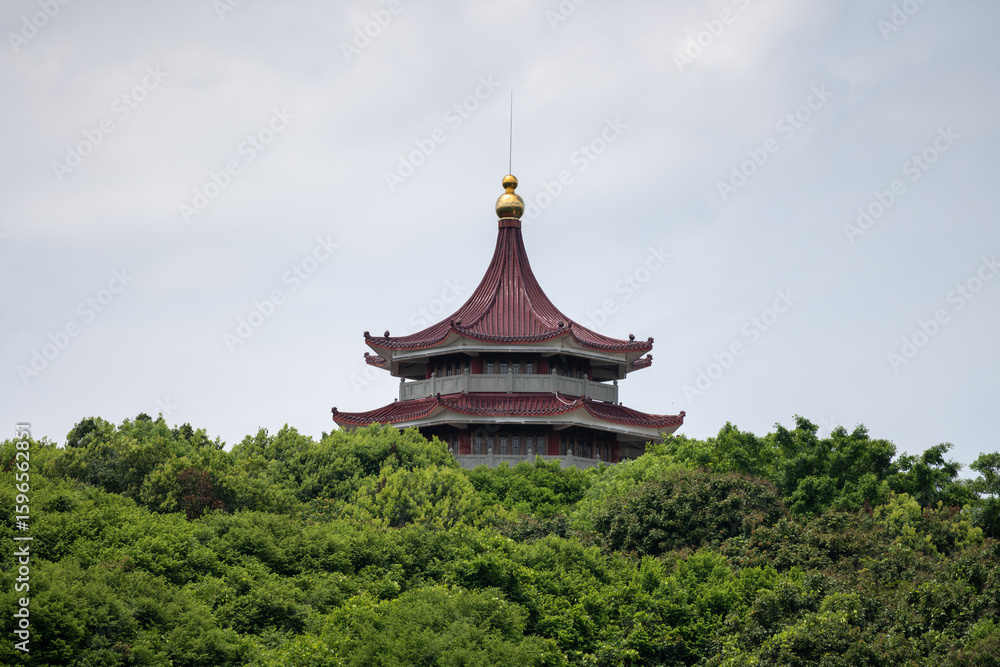 A Traditional Chinese Pavilion Perched on a Lush Green Hilltop A Traditional Chinese Pavilion Perched on a Lush Green Hilltop