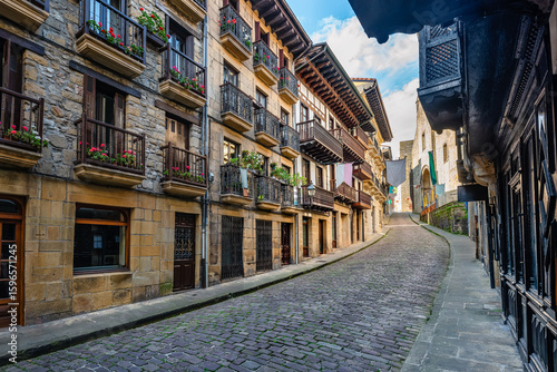 Narrow cobbled streets with flowered balconies and old buildings in the tourist town of Hondarribia, Guipuzcoa.