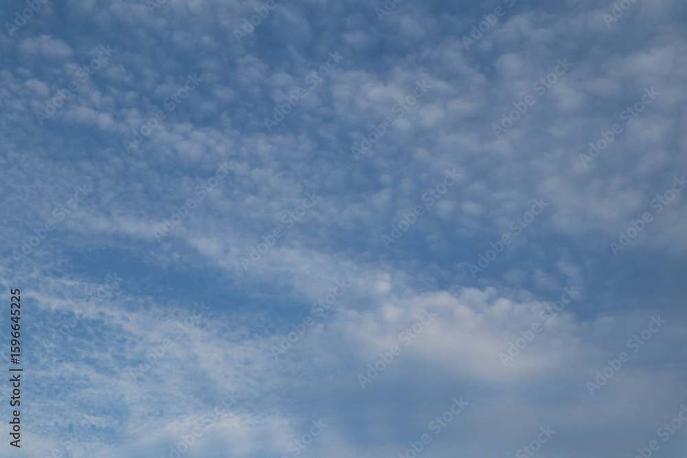 Obraz premium A beautiful blue sky with wispy clouds, perfect for a calming and serene atmosphere.