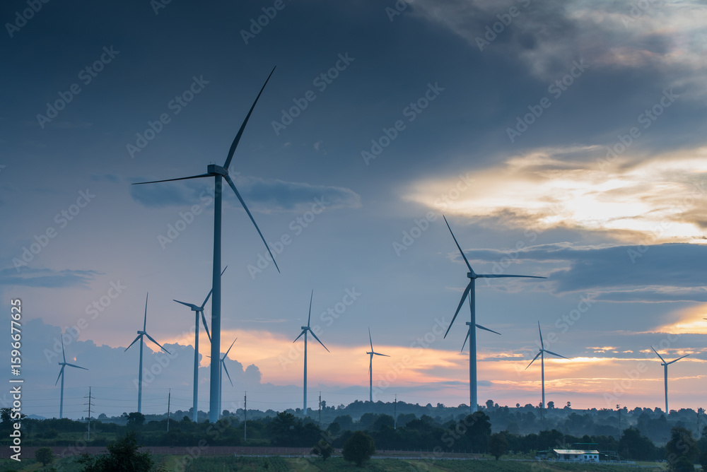 Obraz premium Electricity generating station, Wind turbines power generator in agricultural fields at sunset, Alternative Energy Windmill Farm
