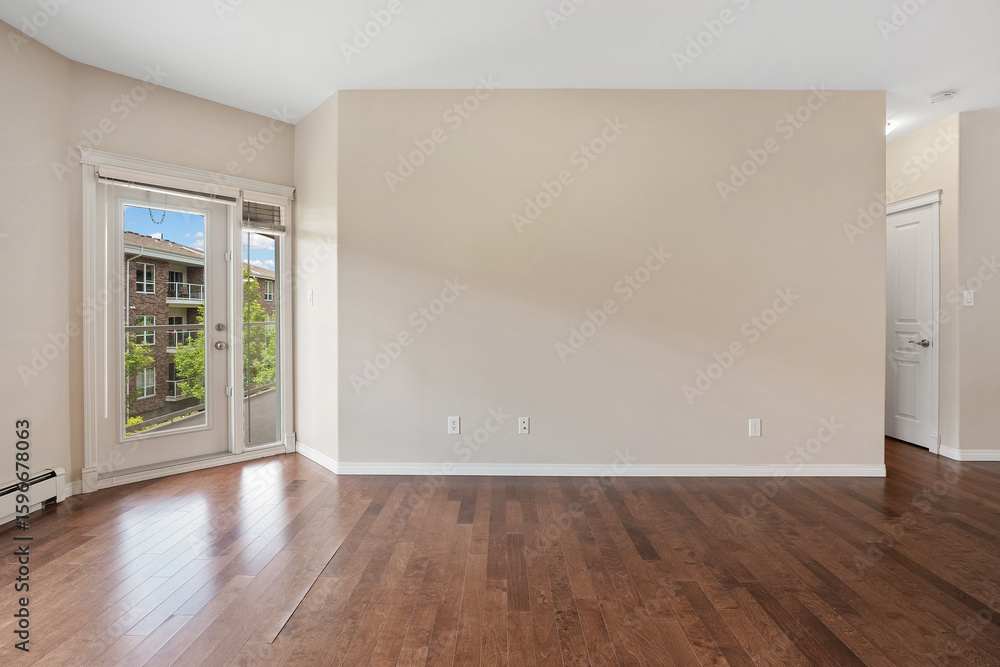 Fototapeta premium Large, empty room with a wooden floor and a door
