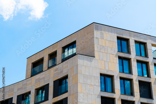 Wallpaper Mural Modern residential corner building with beige stone cladding and blue windows Torontodigital.ca