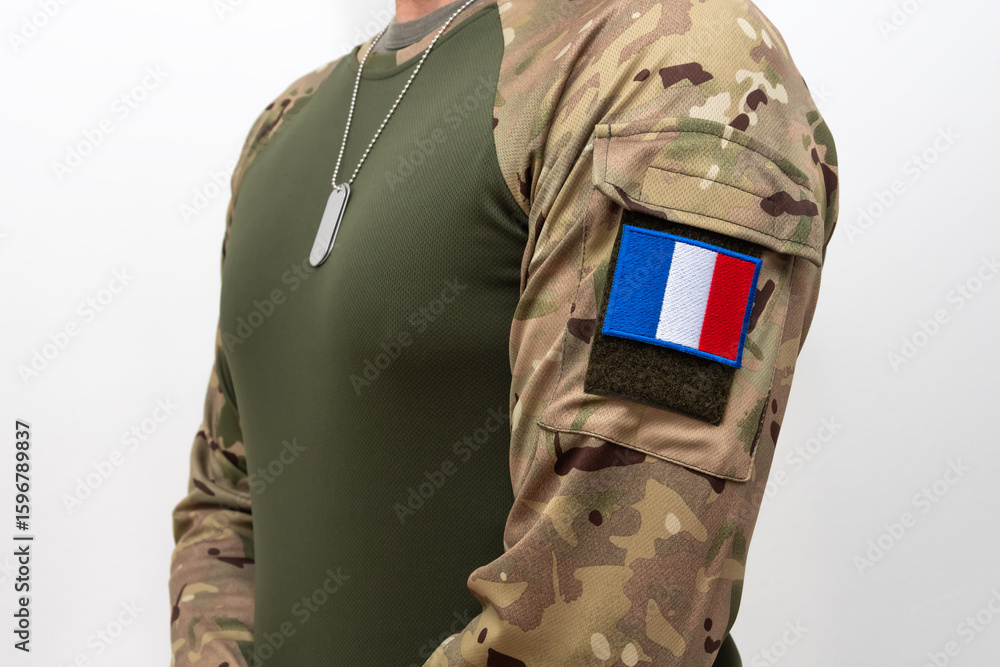 Fototapeta premium French soldier in tactical clothing with camouflage sleeves and metal badges.