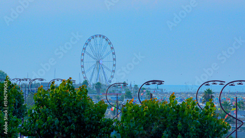 Aerial view of large equipped sandy beaches. Umbrellas and sun loungers for vacationers by the sea. Vacation on the Adriatic Sea. Ferris wheel. Traveling on Europe. Vacation in Italy Rimini 21.08.2025