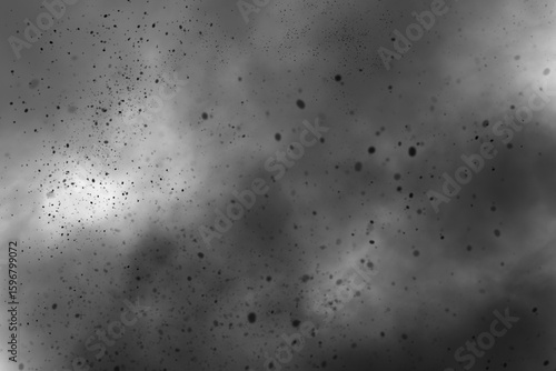 Abstract grayscale image of a smoky texture with scattered particles and blurred cloud shapes effect