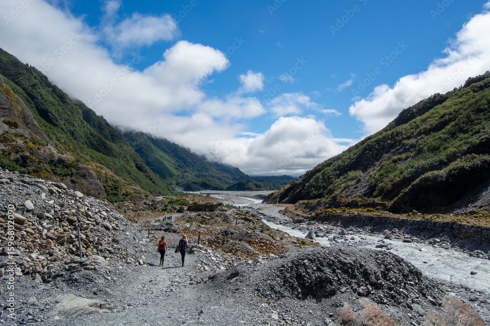 Fototapeta premium Hikers Exploring a Scenic Rocky Riverbed