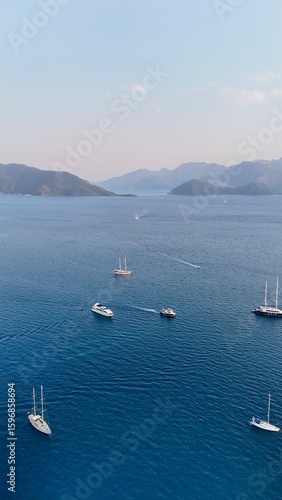 Sunset coastal city. Boats coastal town. Coastal mountain landscape, sea resort yachts, golden hour