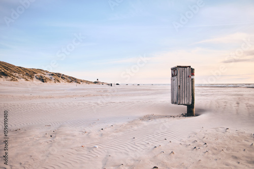 Trash can on wide sandy beach. High quality photo