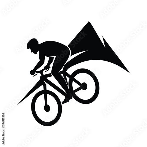 Silhouette of cyclist performing wheelie with mountain background