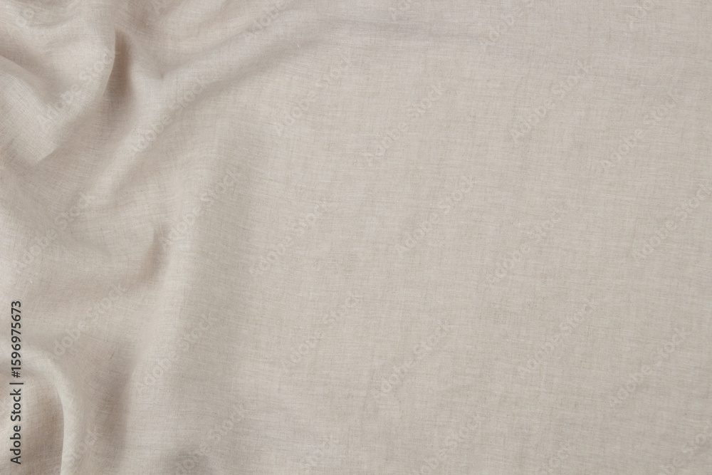 Naklejka premium Soft draped beige linen background. Natural eco friendly fabric texture with draperies in left side