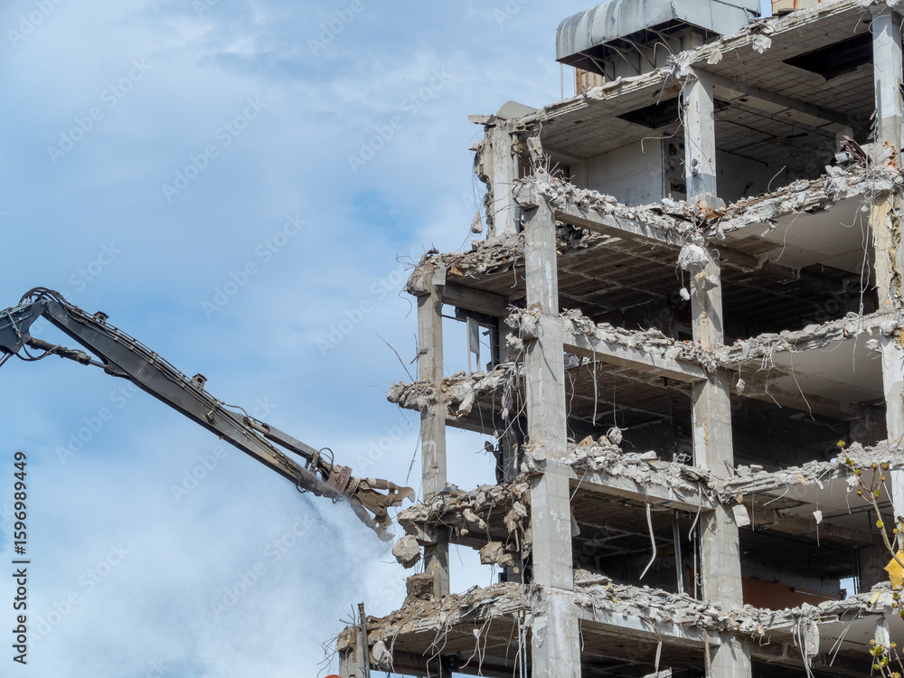 Demolition of a concrete building in an urban area during daylight with heavy machinery at work Demolition of a concrete building in an urban area during daylight with heavy machinery at work