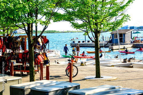 Photography paddlers launching  kayaks from a busy dock on a big city harbour on a summer ev
