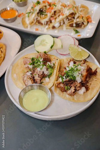 Mexican Pork Carnitas Tacos with Vegetable Garnish, Lime, Cilantro, Onions