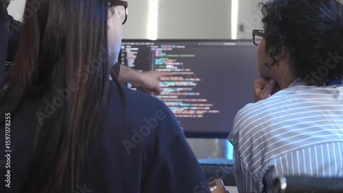 A team of female software developers in a pair programming session, reviewing and debugging code together. Concept for Women in Tech, agile development, and collaboration.