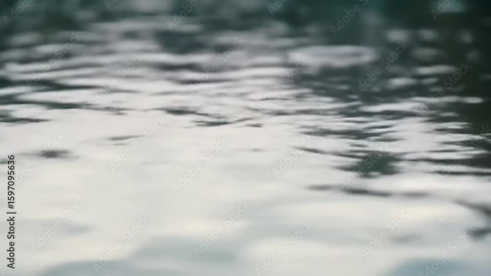 Water surface with reflections blurred and textured showing various light and dark patterns Water surface with reflections blurred and textured showing various light and dark patterns