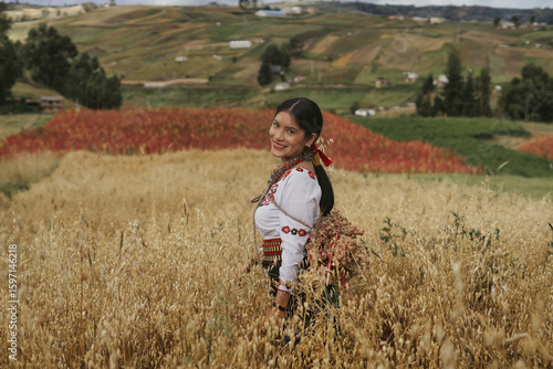 Indigenous farmer carrying harvested amaranth in ecuadorian andes mountains