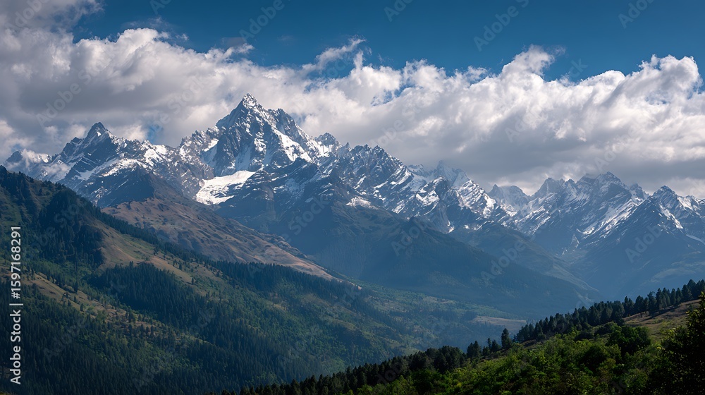 Fototapeta premium SnowCapped Mountain Range Under Blue Sky with Clouds, Lush Green Forest Slopes