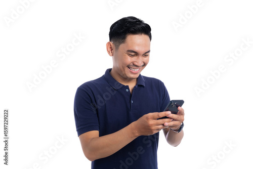 Smiling young Asian man looking down and using smartphone isolated on transparent background