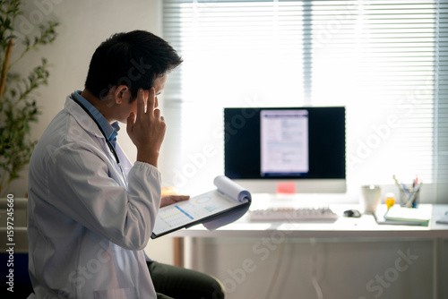 Wallpaper Mural doctor is sitting at a desk with a computer monitor and a clipboard Torontodigital.ca