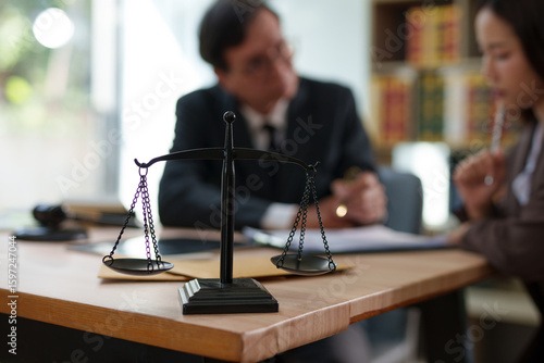Lawyers are sitting in a meeting, searching for legal documents at the office.	
